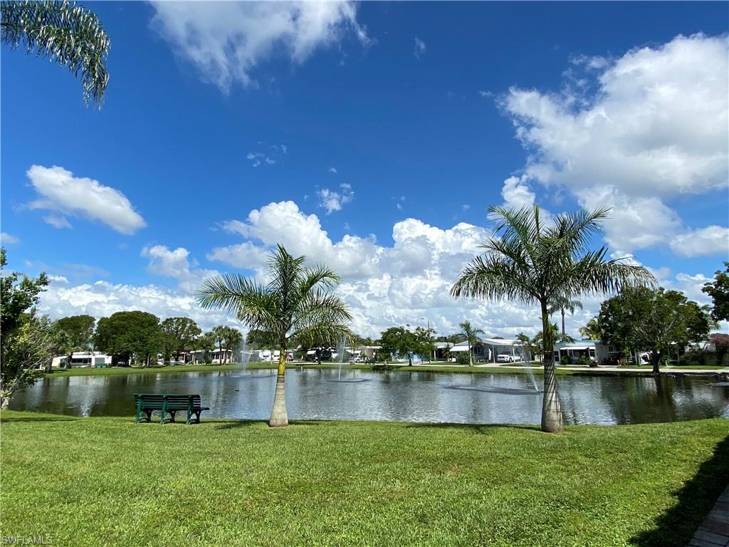 Expansive green lawn bordering a tranquil pond with multiple water features