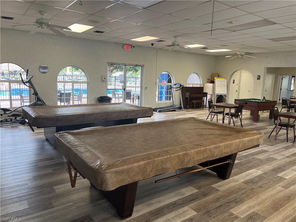 Recreation room featuring wood-finish flooring and arched windows