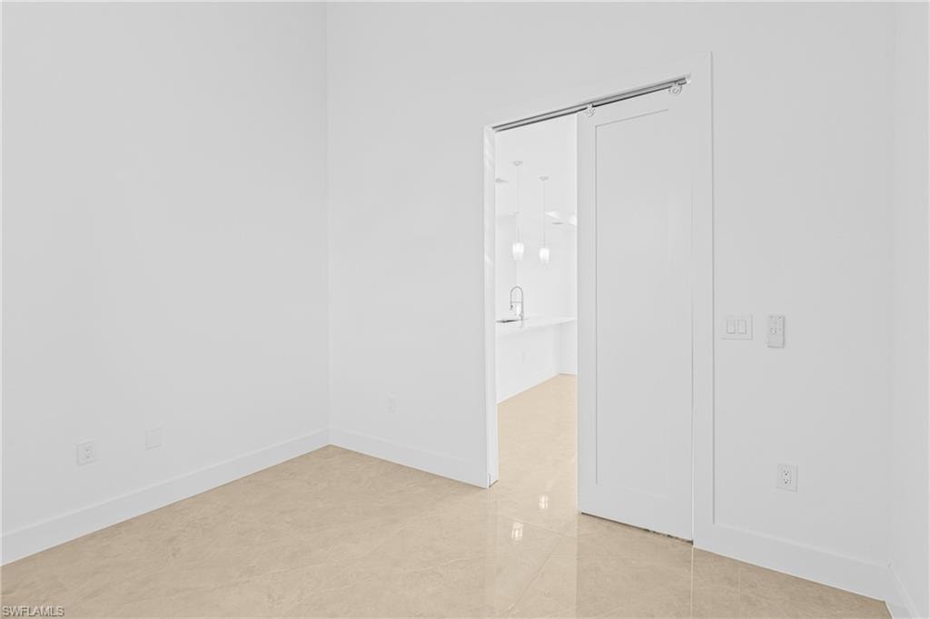 Unfurnished room featuring light tile patterned floors and baseboards
