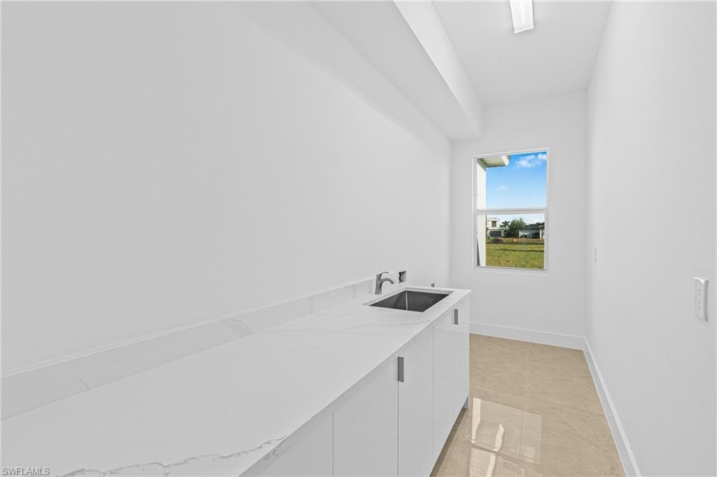 Laundry area with washer hookup and light tile patterned floors