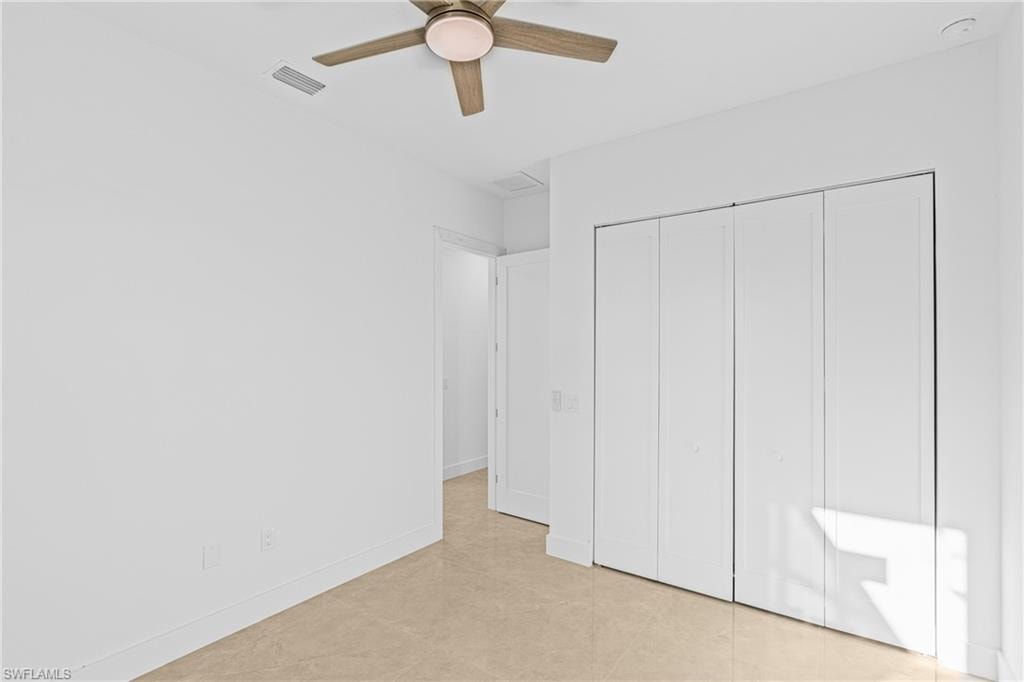 Unfurnished bedroom with a closet, ceiling fan, and light tile patterned floors