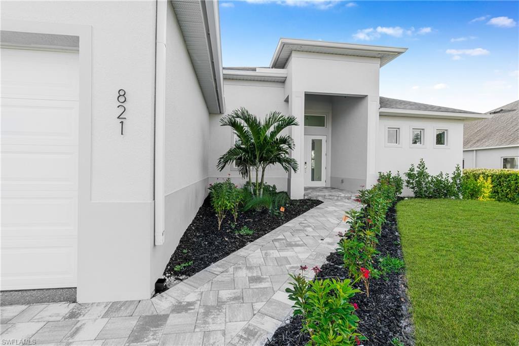 Doorway to property featuring stucco siding and a yard