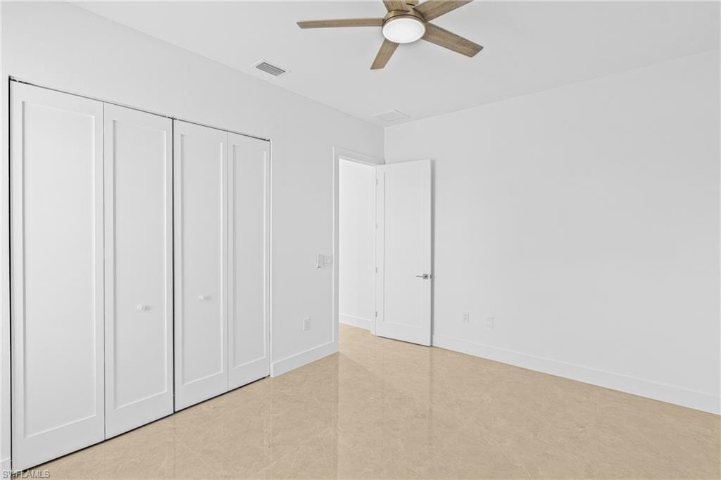 Unfurnished bedroom with a closet, ceiling fan, and light tile patterned flooring