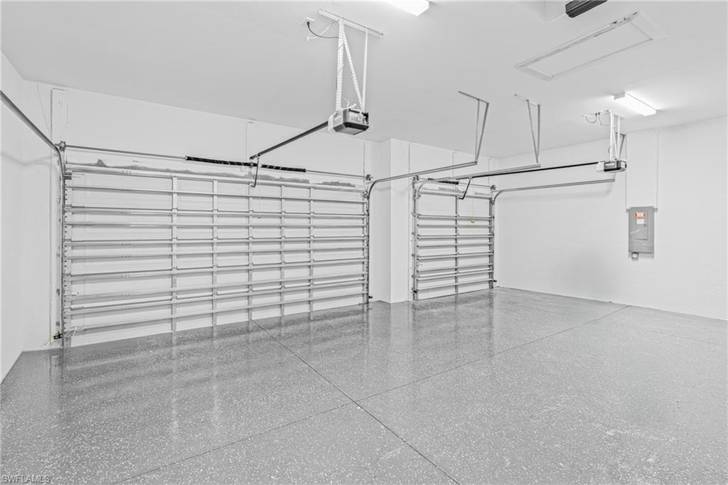 Garage featuring electric panel and a garage door opener