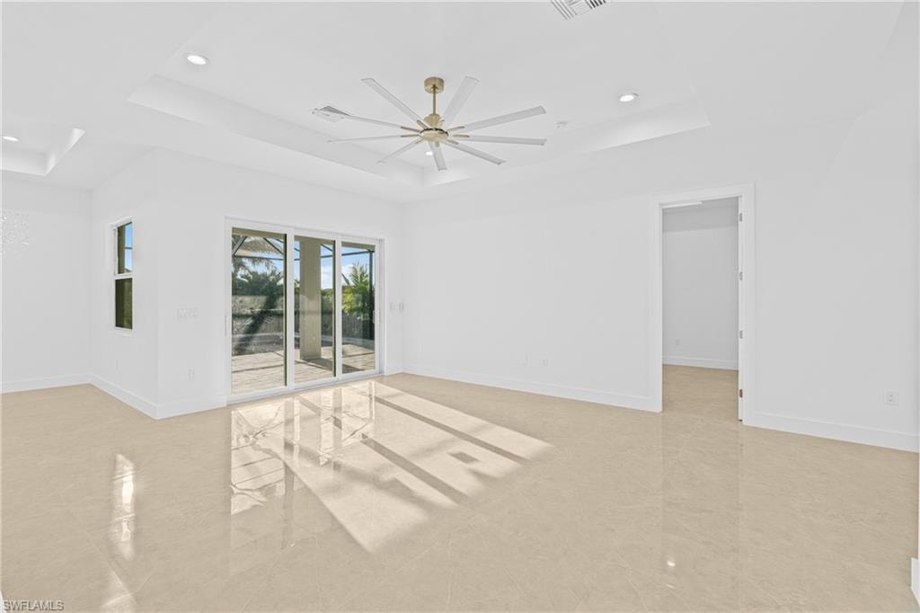 Unfurnished room featuring a tray ceiling, a ceiling fan, and recessed lighting