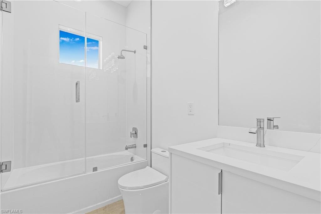 Bathroom featuring enclosed tub / shower combo and vanity