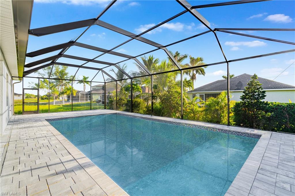 Outdoor pool with a lanai, a sunroom, and a patio area