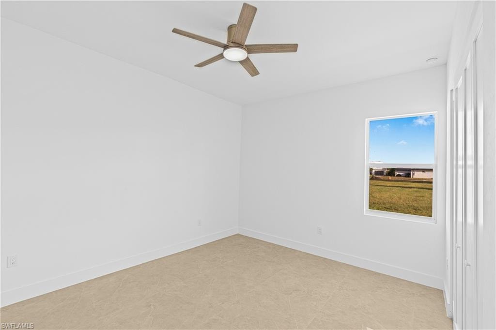 Spare room with baseboards and ceiling fan