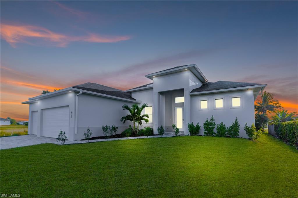 Modern home featuring a front yard, stucco siding, concrete driveway, and an attached garage