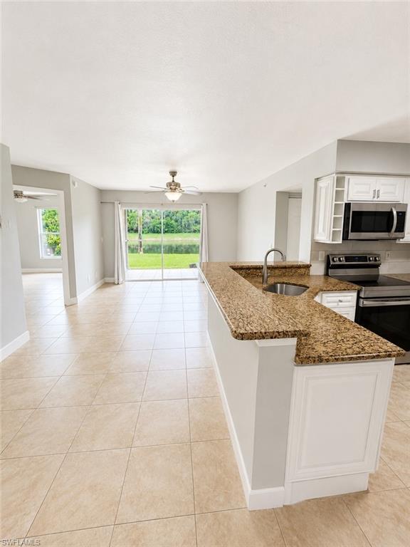 Kitchen features a granite-top breakfast bar with built-in sink and white paneled cabinetry