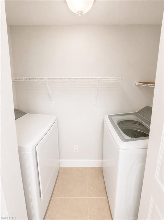 Dedicated laundry area featuring ceramic tile flooring, a white wire shelf, and an additional small shelf