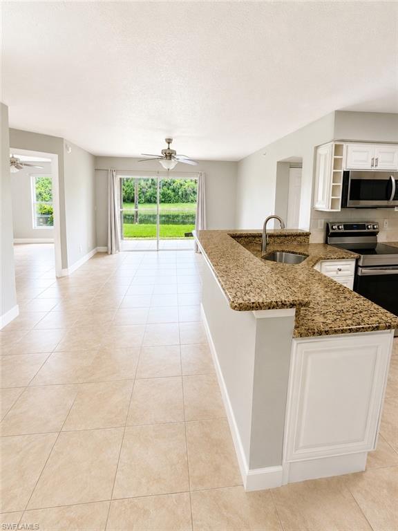 Kitchen island with granite countertop and integrated sink featuring a pull-down faucet
