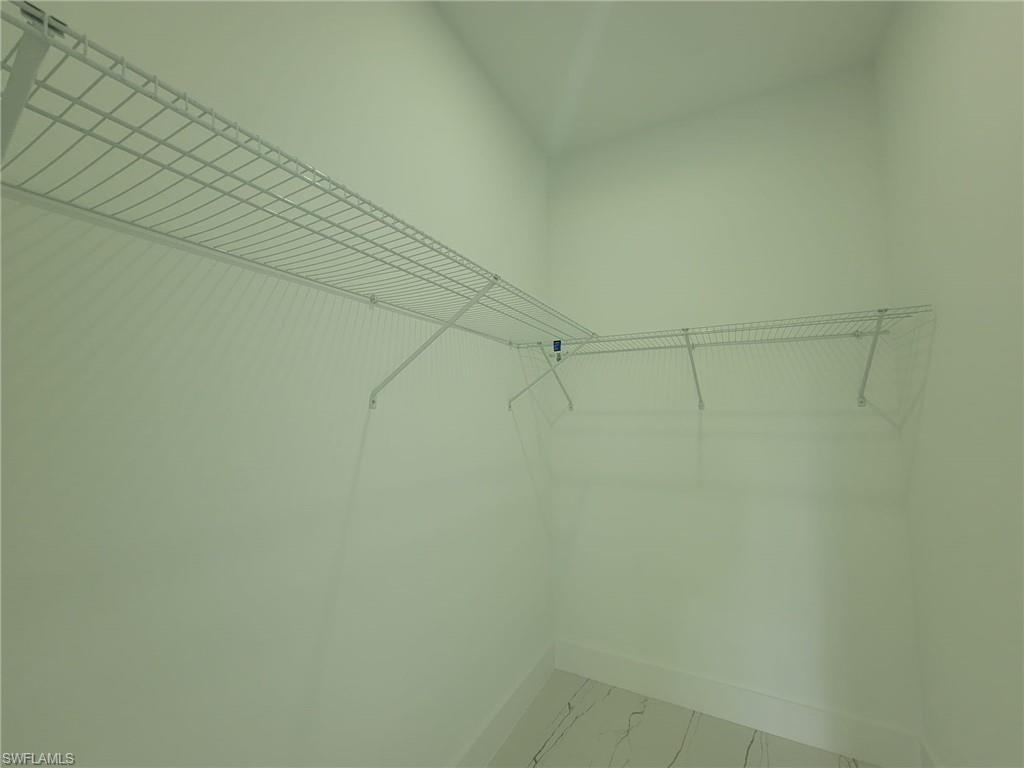 Walk in closet with tile patterned flooring