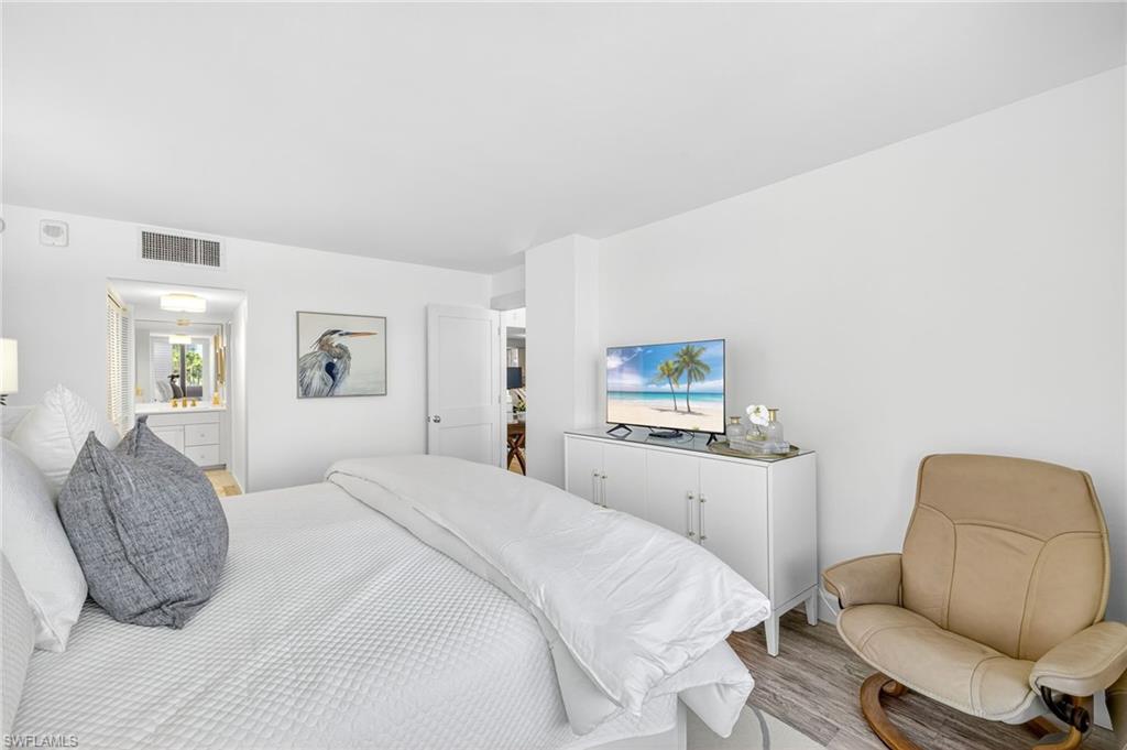 Bedroom with light wood-style flooring and ensuite bathroom.