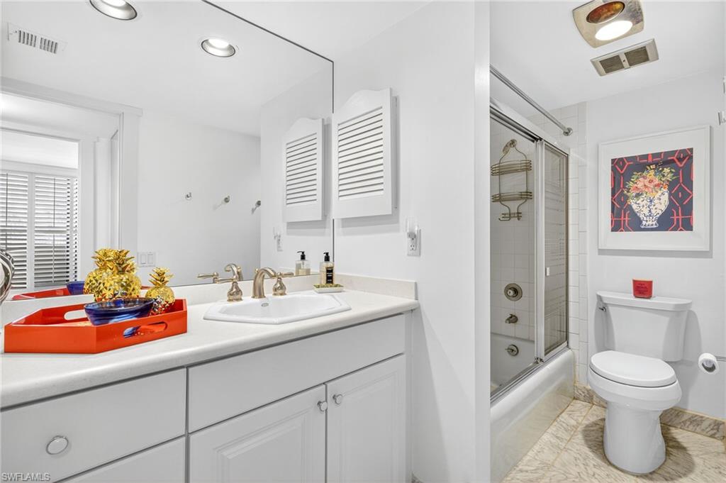Bathroom with vanity, tub / shower with glass door,.