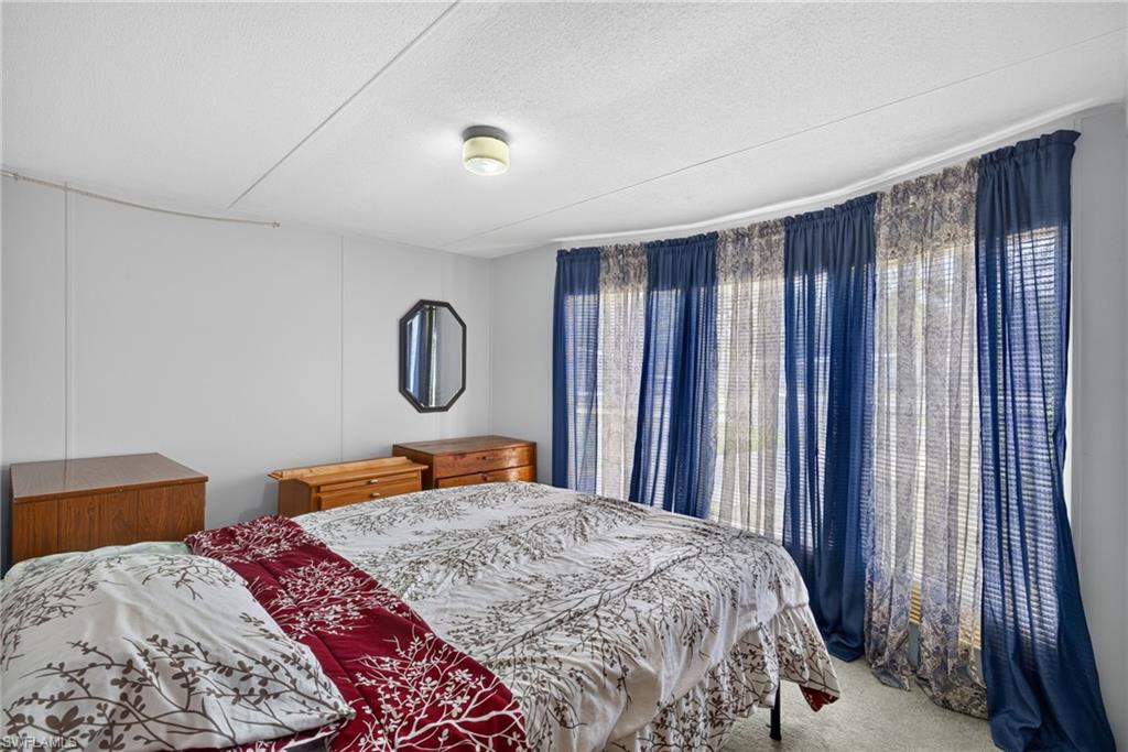 Curved wall with multiple windows featuring full-length blue and patterned sheer draperies