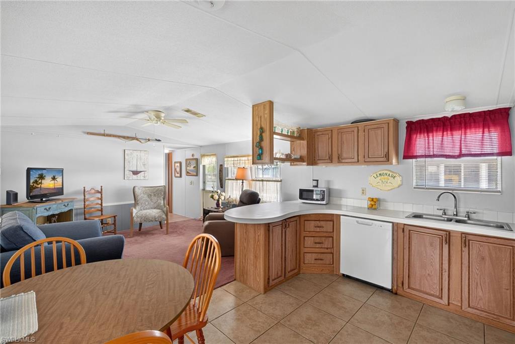 Kitchen featuring wood-finish cabinetry, white countertop, and tile flooring