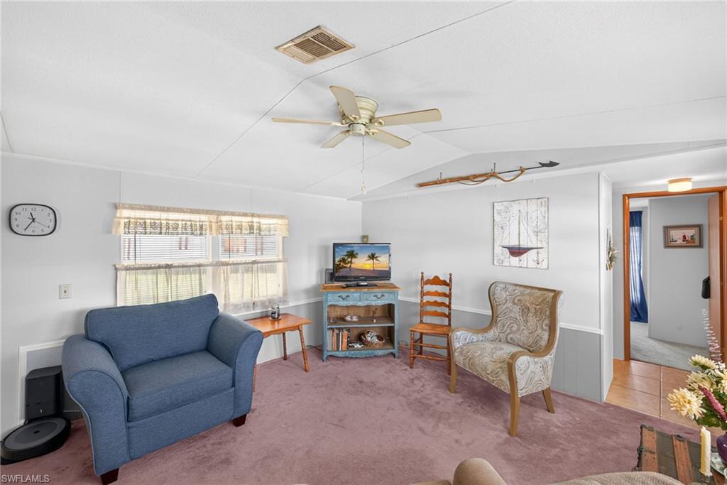 Living area featuring plush carpeting and a ceiling fan