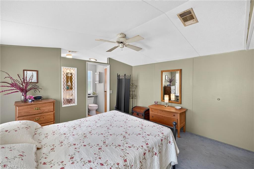 Bedroom featuring light green wall paneling and blue carpeting