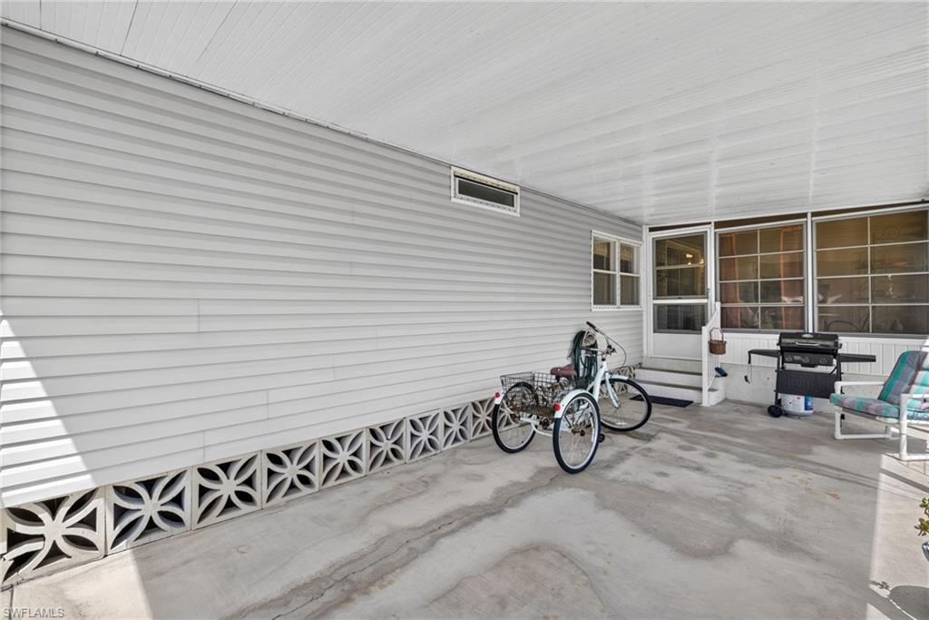 Covered concrete carport with white vinyl siding