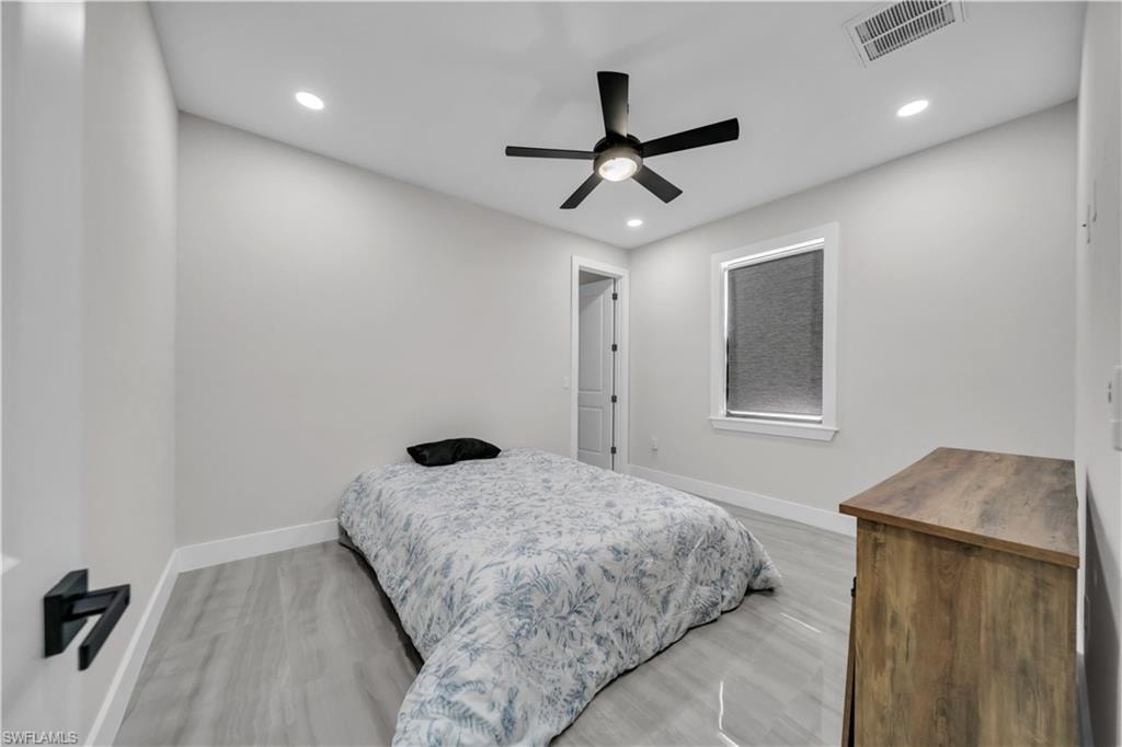 Recessed lighting, wood-finish flooring, and a contemporary ceiling fan with integrated lighting