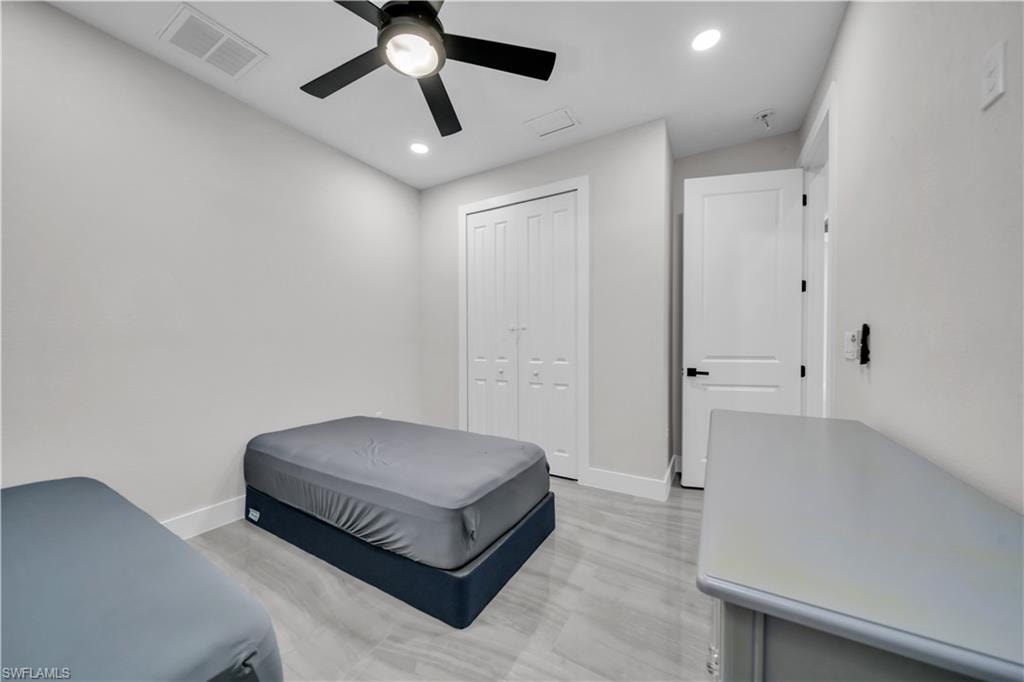 Recessed lighting, wood-finish flooring, a ceiling fan, and a built-in closet with bifold doors