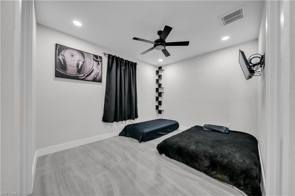 Recessed ceiling lighting, wood-finish flooring, and a ceiling fan with integrated lighting