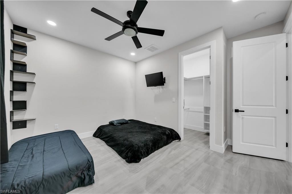 Recessed lighting, a ceiling fan, and wood-finish flooring