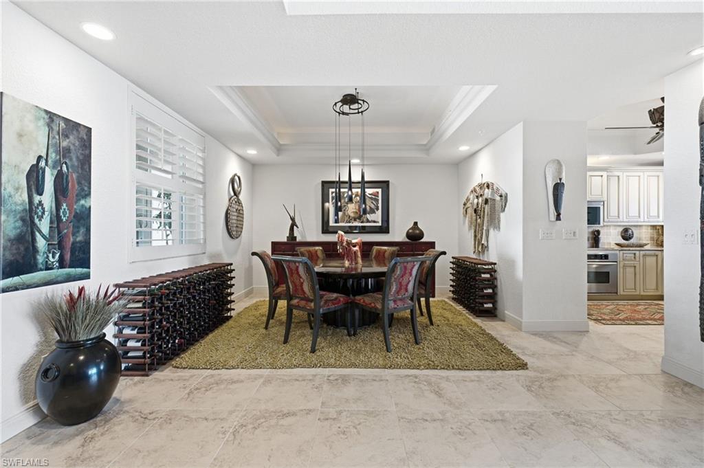 The elegant dining area is beautifully appointed with a sophisticated tray ceiling, ambient uplighting, abundant natural light, and recessed lighting, creating an inviting setting for intimate dinners and memorable gatherings.