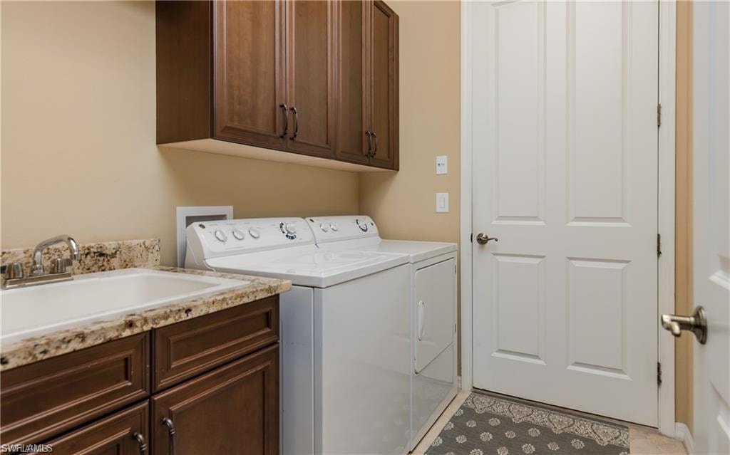 Laundry room featuring cabinet space, independent washer and dryer, and light tile patterned floors