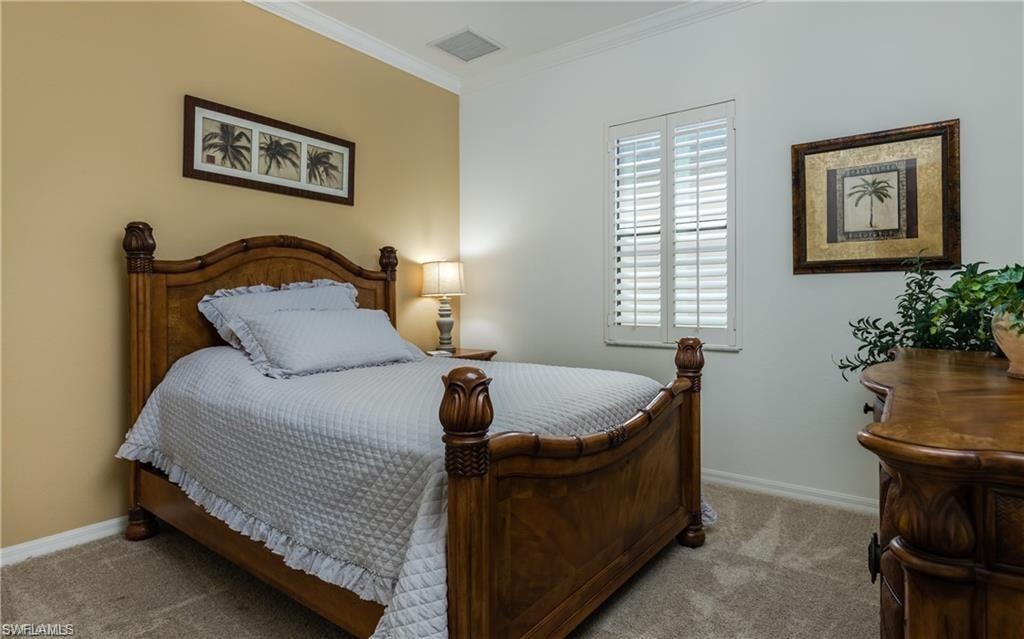 Bedroom with crown molding and carpet