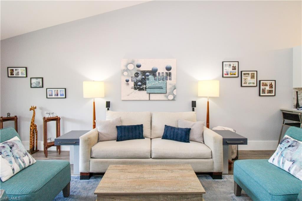 Living room featuring vaulted ceiling and hardwood / wood-style flooring