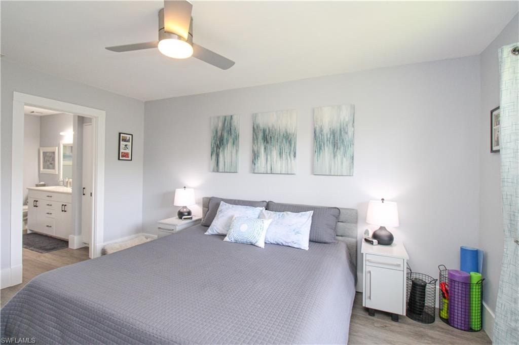 Bedroom featuring light hardwood / wood-style floors, connected bathroom, sink, and ceiling fan