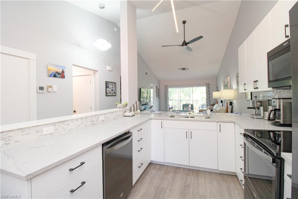 Kitchen with light hardwood / wood-style flooring, kitchen peninsula, dishwasher, ceiling fan, and range with electric stovetop