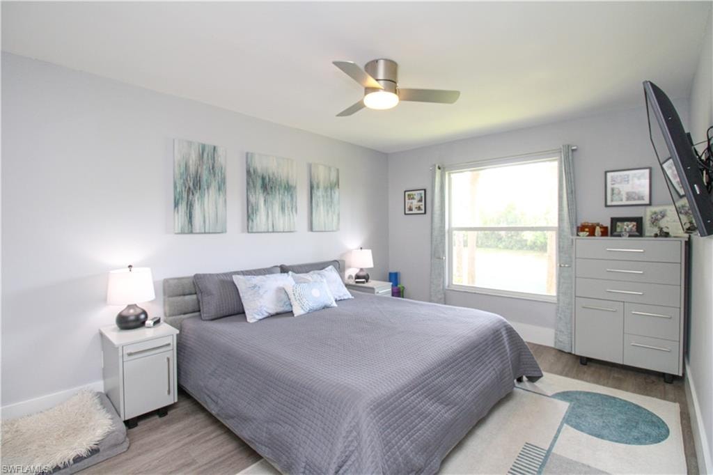 Bedroom with ceiling fan and light wood-type flooring