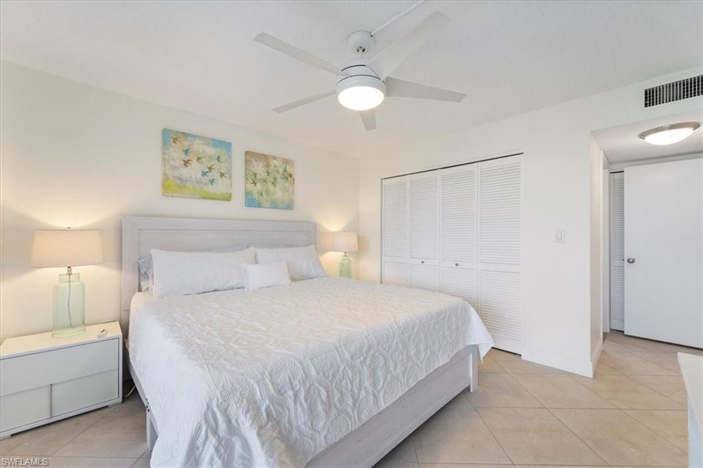 Bedroom with light tile patterned floors, a closet, and a ceiling fan