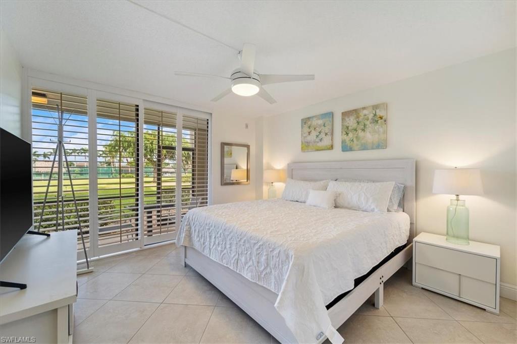 Bedroom featuring access to outside, light tile patterned flooring, ceiling fan, and floor to ceiling windows