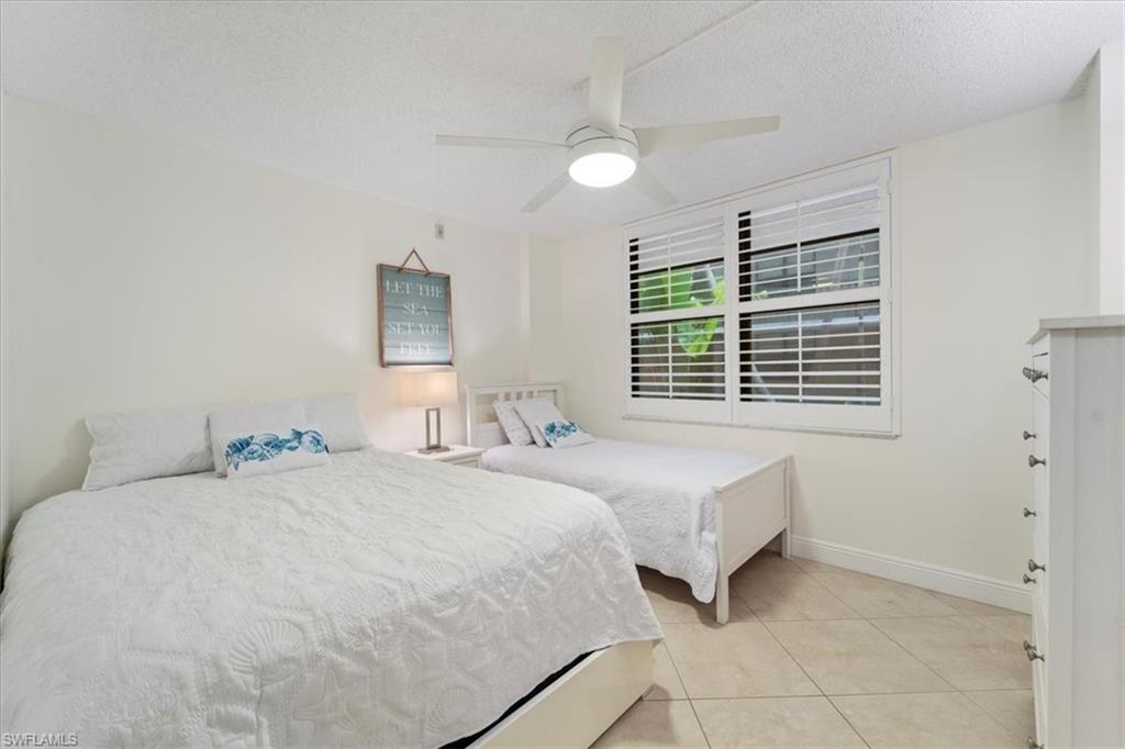 Bedroom featuring light tile patterned flooring, a textured ceiling, and ceiling fan