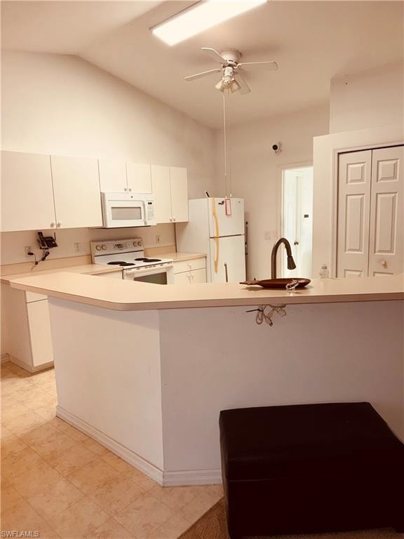 Kitchen with a peninsula, light countertops, white appliances, white cabinets, and ceiling fan
