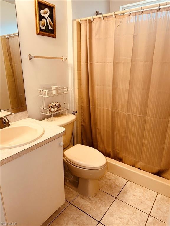 Bathroom featuring curtained shower, vanity, and light tile patterned floors