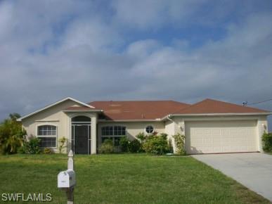 Ranch-style house featuring a front lawn, driveway, stucco siding, and a garage