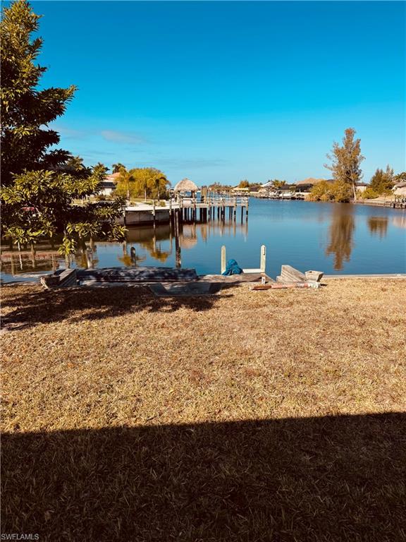 Dock area featuring a water view and a lawn