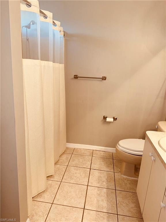 Full bath featuring a shower with shower curtain, vanity, and light tile patterned floors