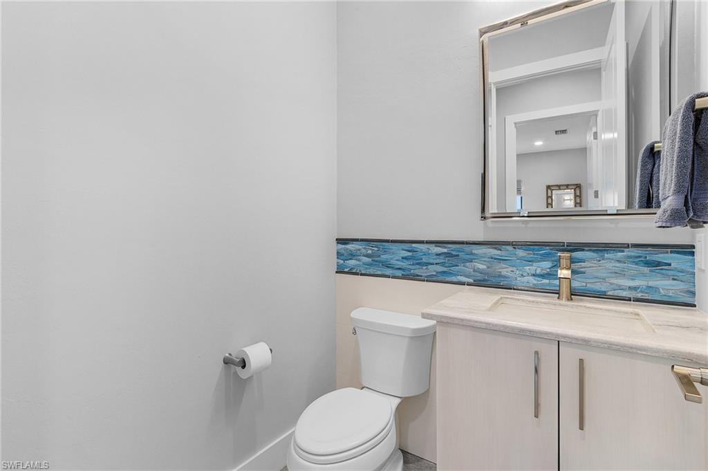 Bathroom featuring tasteful backsplash, vanity, and toilet