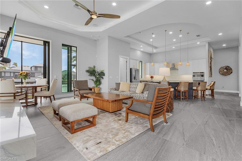 Living room featuring ceiling fan and a raised ceiling