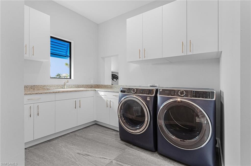Laundry area featuring cabinets, independent washer and dryer, and sink