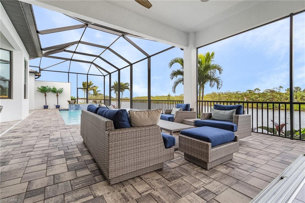 View of patio / terrace featuring outdoor lounge area, pool water feature, a water view, and glass enclosure