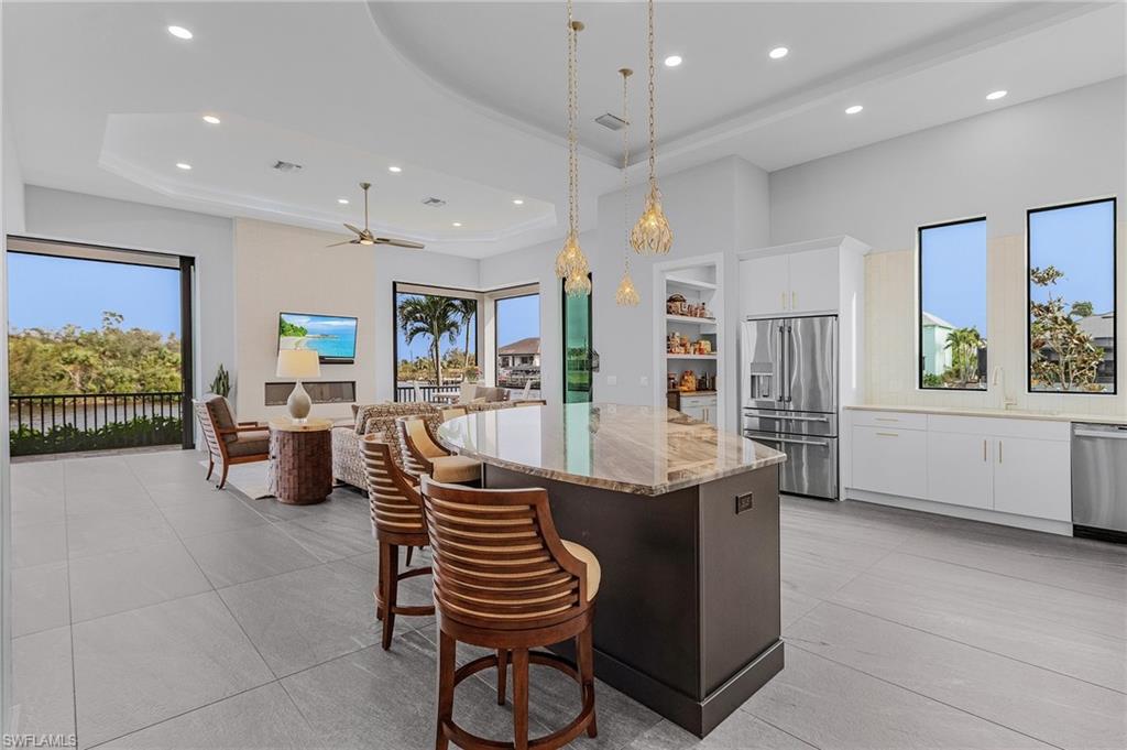 Kitchen featuring plenty of natural light, white cabinets, stainless steel appliances, and a kitchen island