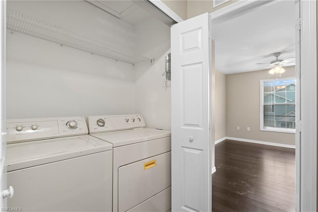 Laundry closet with wire shelving and a full-size washer and dryer