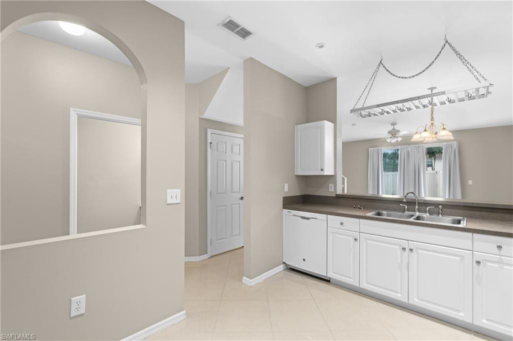 Kitchen featuring white cabinetry, a double basin stainless steel sink, and a dishwasher